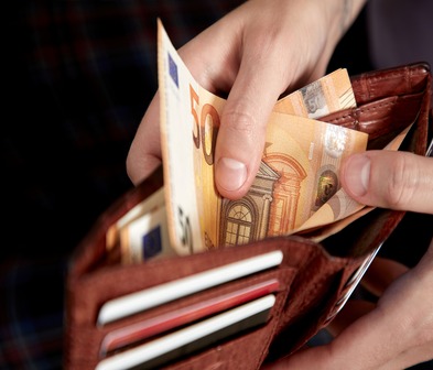Un homme qui sort un billet de 50 euros de son portefeuille